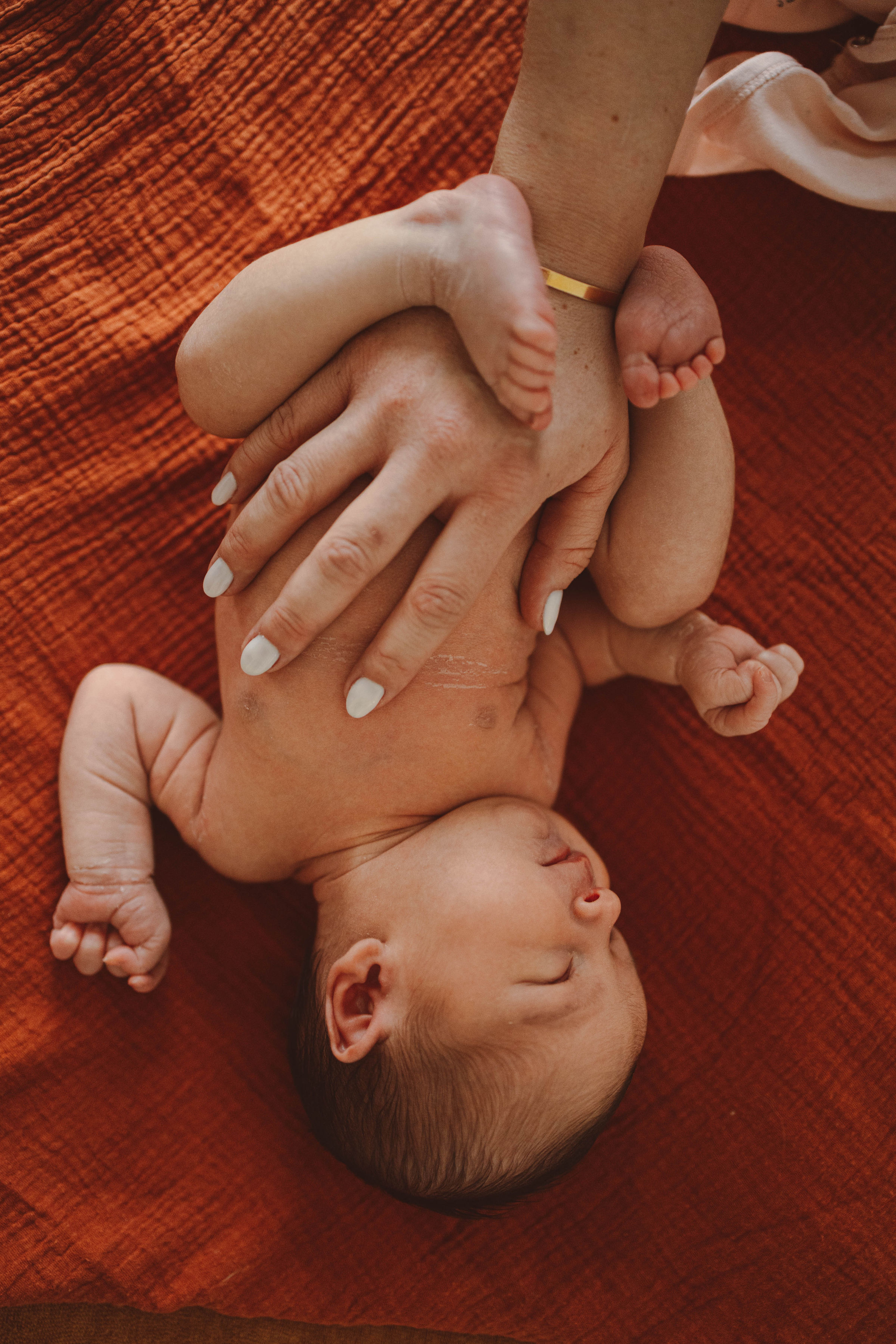 Un change tout en douceur entre les mains de sa maman pour la petite Capucine avant de commencer le bain